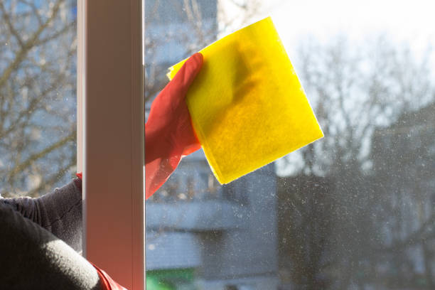 wycieranie szyby żółtą ściereczką po usunięciu naklejki i resztek kleju