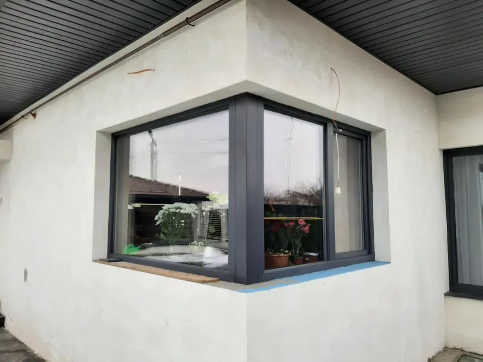 nowoczesne okno narożne w kolorze antracytowym na elewacji budynku