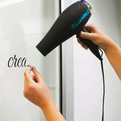 usuwanie naklejki z szyby okiennej przy użyciu suszarki do włosów